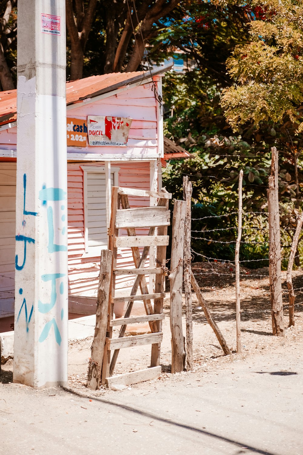 a wooden fence with graffiti on it next to a building