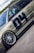 A detailed view of a customized car with prominent wheel rims and a matte finish. The car features decals and sponsor logos, highlighting brands such as BBS and Recaro, with a large number 04 on the side. The vehicle is positioned on a smooth road surface, with greenery visible in the background under a partly cloudy sky.