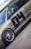 A detailed view of a customized car with prominent wheel rims and a matte finish. The car features decals and sponsor logos, highlighting brands such as BBS and Recaro, with a large number 04 on the side. The vehicle is positioned on a smooth road surface, with greenery visible in the background under a partly cloudy sky.