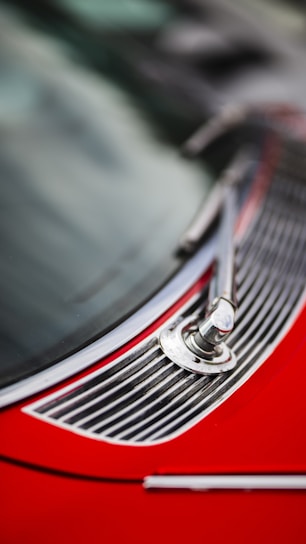 Close-up of a technician carefully fitting a new windscreen wiper blade on a car.