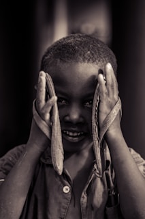 A child smiling brightly while trying on a new pair of sturdy shoes for the first time.