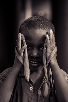 A smiling child in Peru holding new shoes, captured during a live delivery.