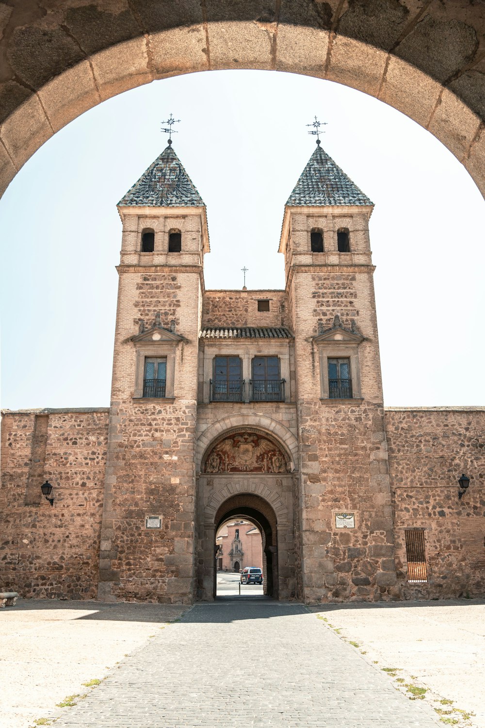 a large brick building with two towers and a gate