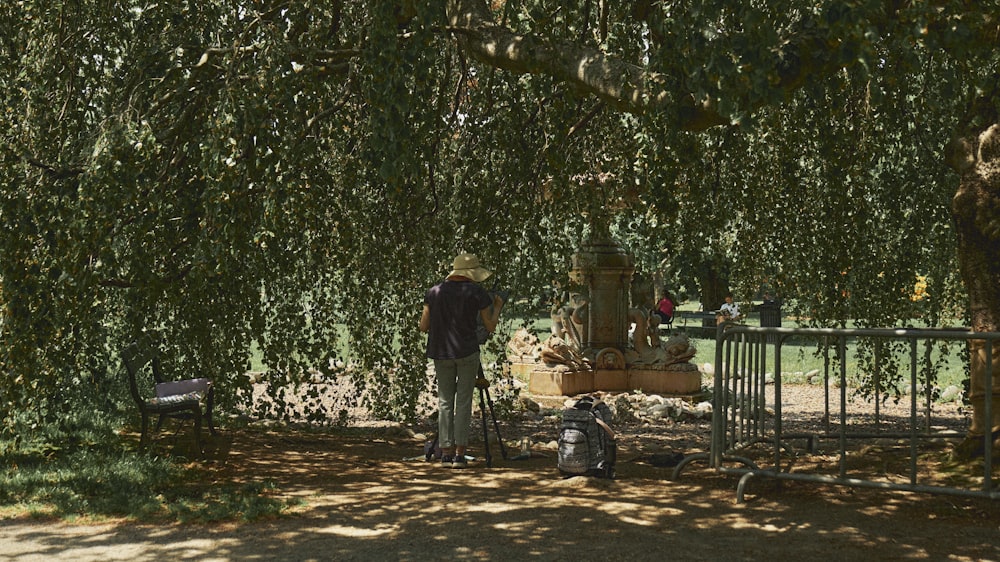 a man standing under a tree next to a fire hydrant