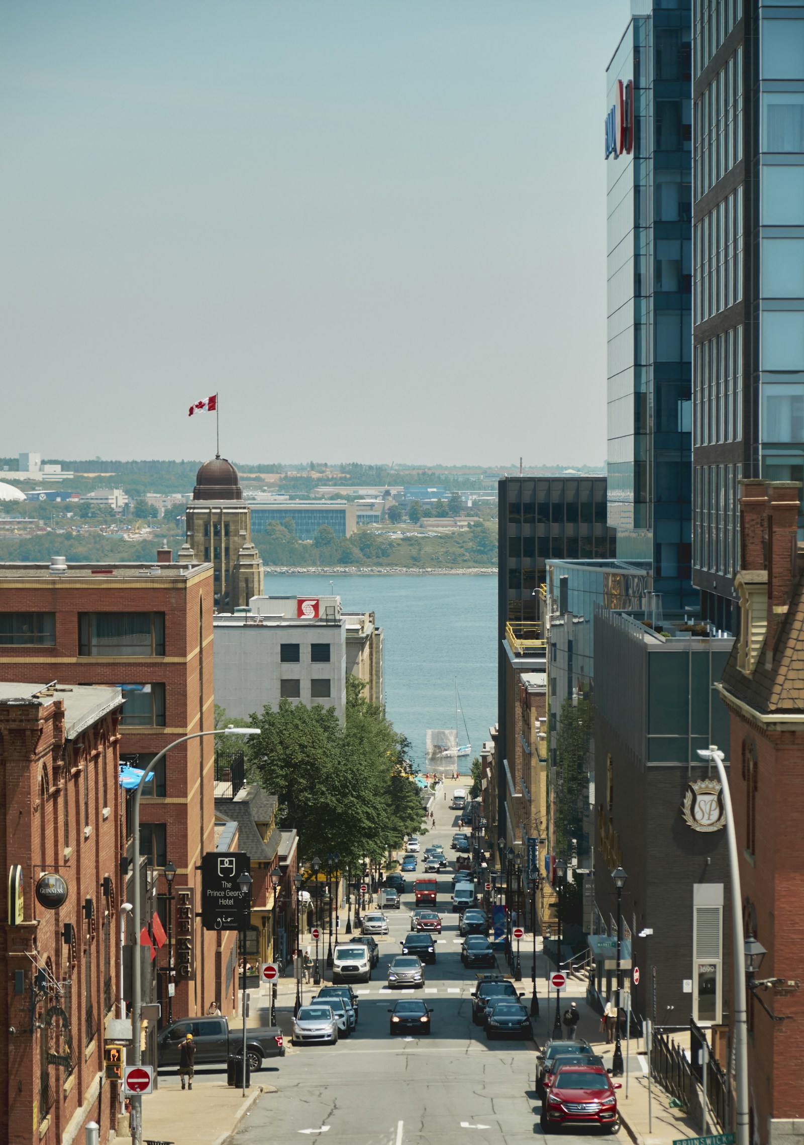 Downtown Halifax street in daytime with cars and harbour in background