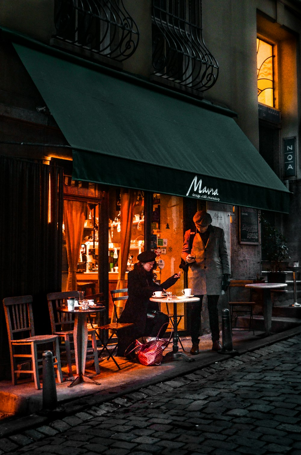 a couple of people standing outside of a restaurant