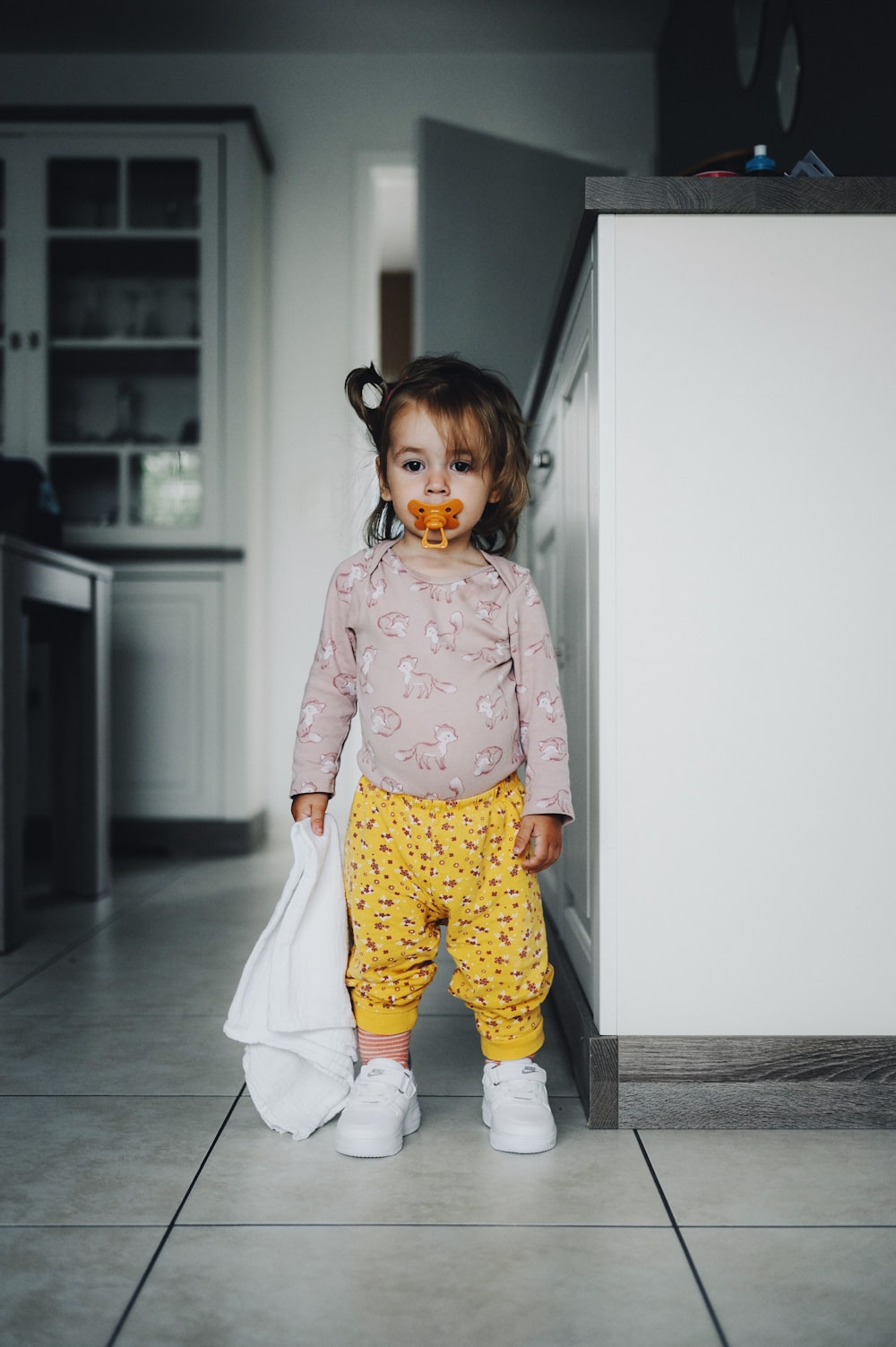 a little girl with a pacifier in her mouth