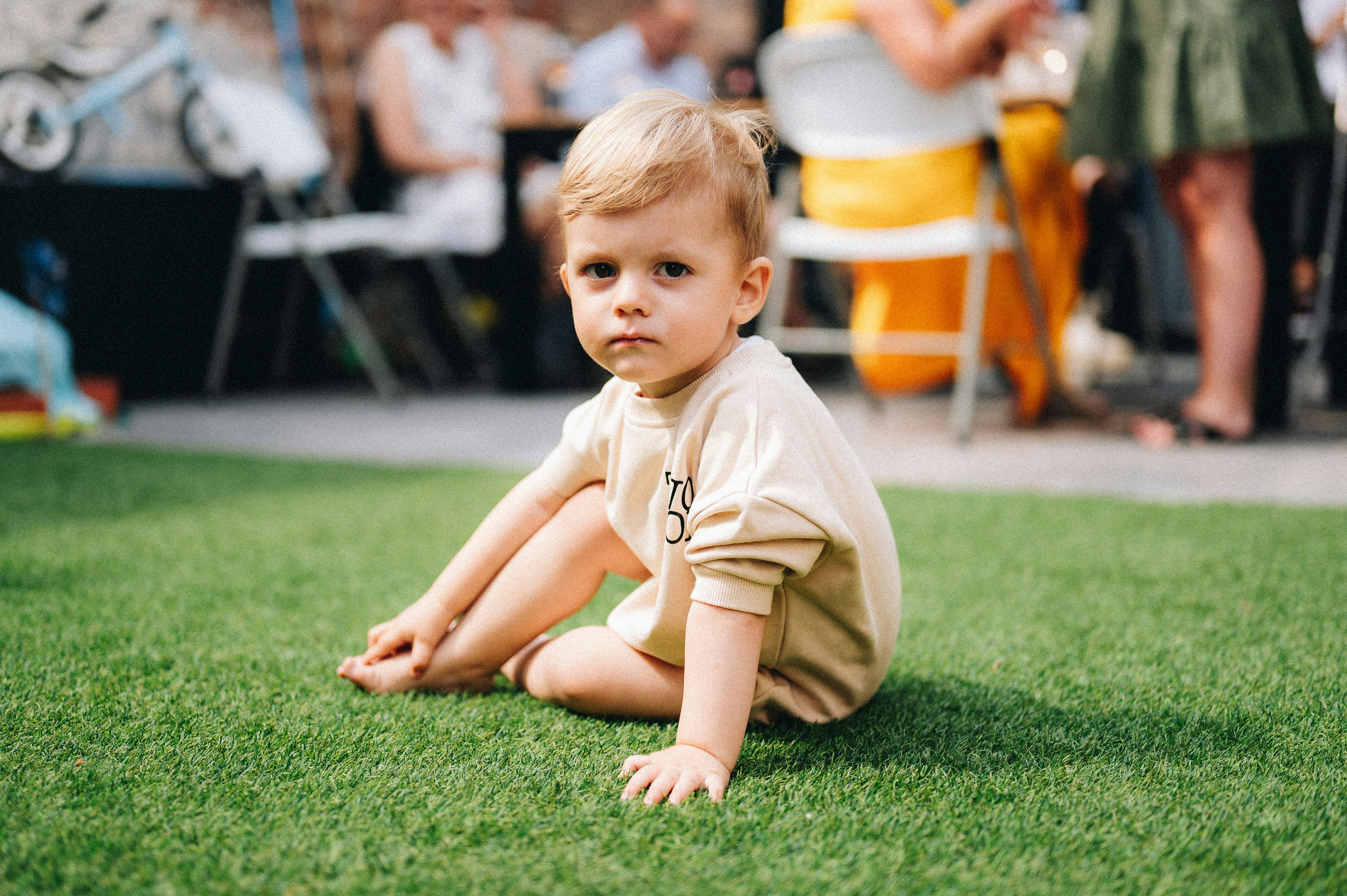 a little boy that is sitting in the grass