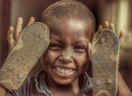 A child trying on a pair of comfortable, handmade shoes with a smile.