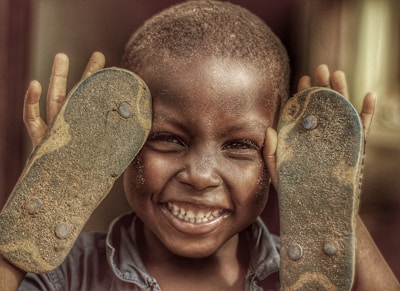 A joyful child in Lagos receiving a new pair of athletic shoes.