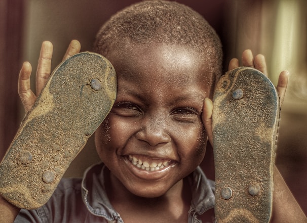 A child smiling brightly while receiving a new pair of durable shoes.