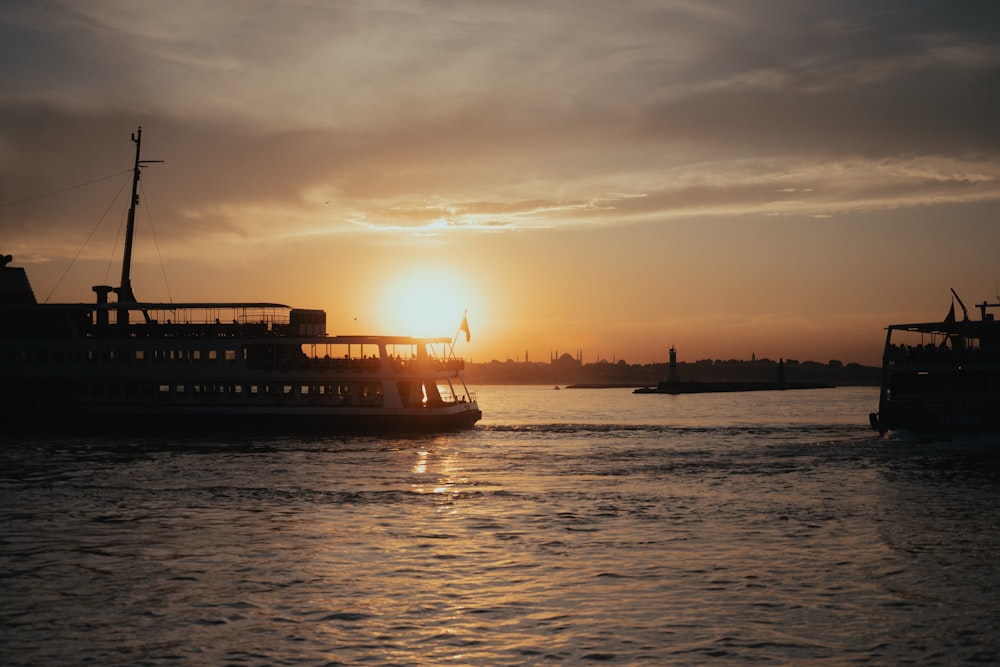 Le soleil se couche sur un grand bateau dans l’eau