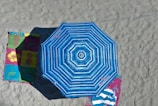 A vibrant beach umbrella with bold stripes planted in the sand on a sunny day