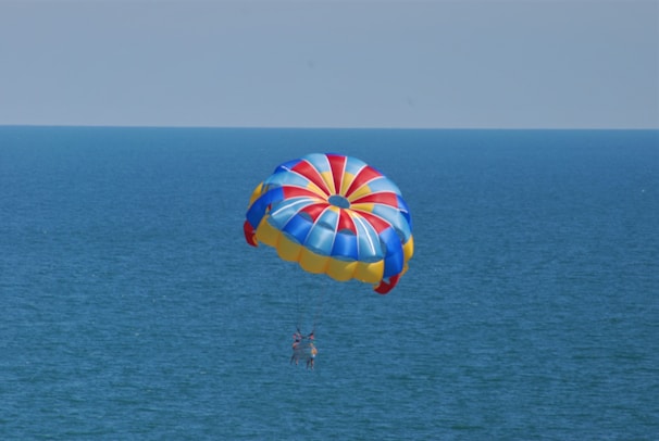 A group of kids lifting a vibrant 5-meter parachute during a school recreation activity