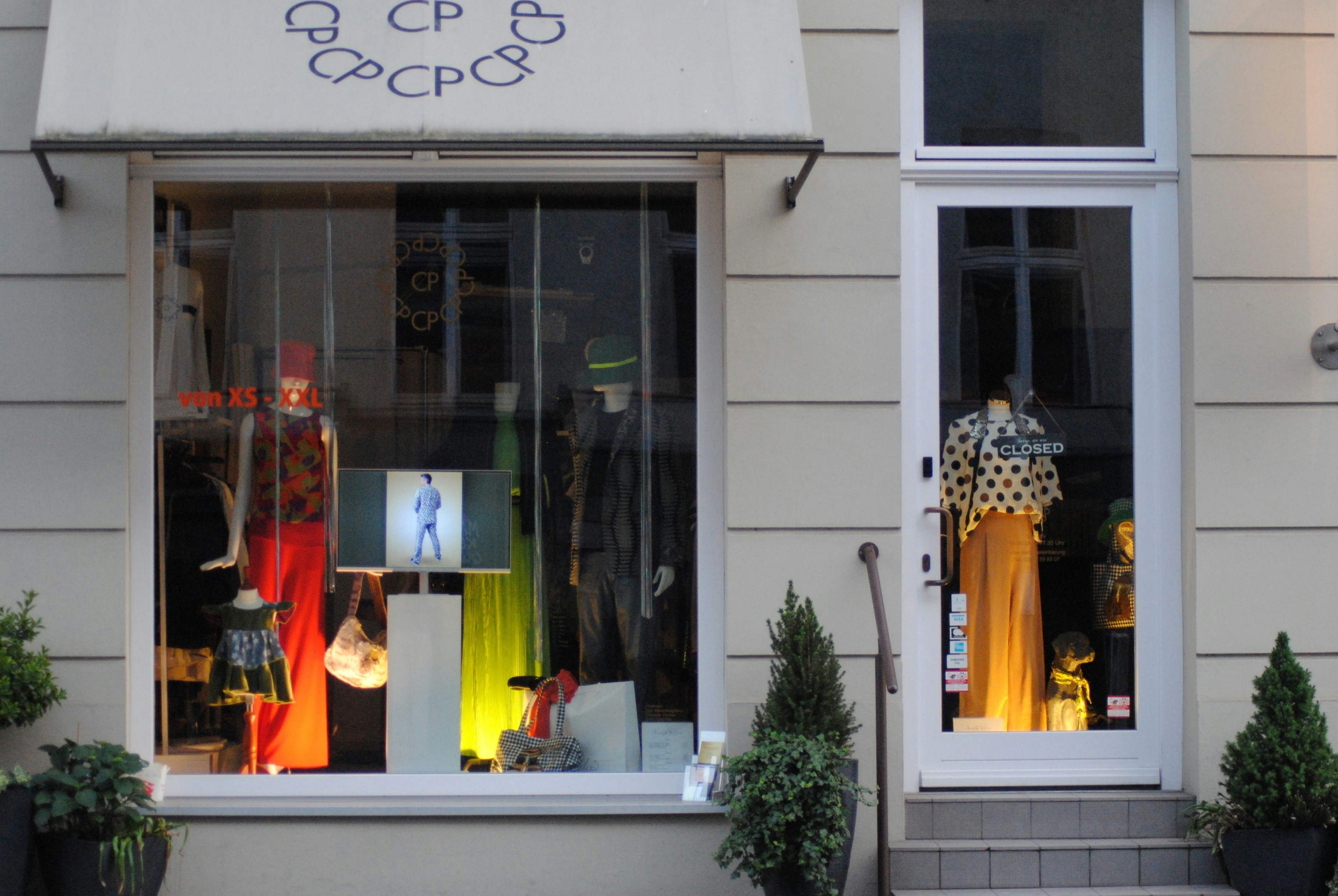 a store front with a display of clothing in the window