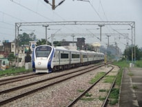 a white and blue train traveling down train tracks