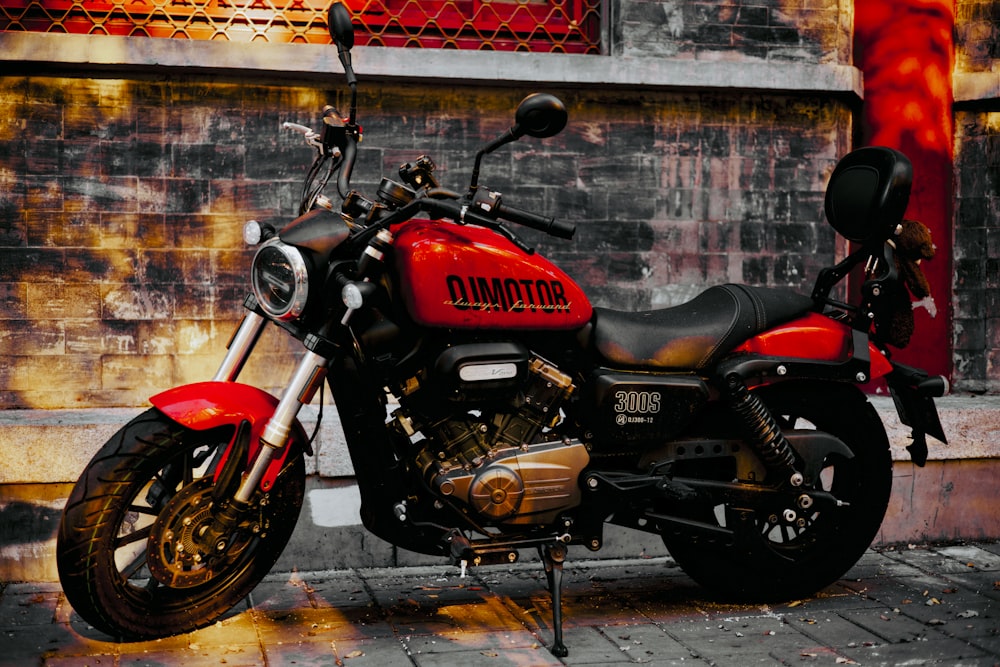a red and black motorcycle parked in front of a building
