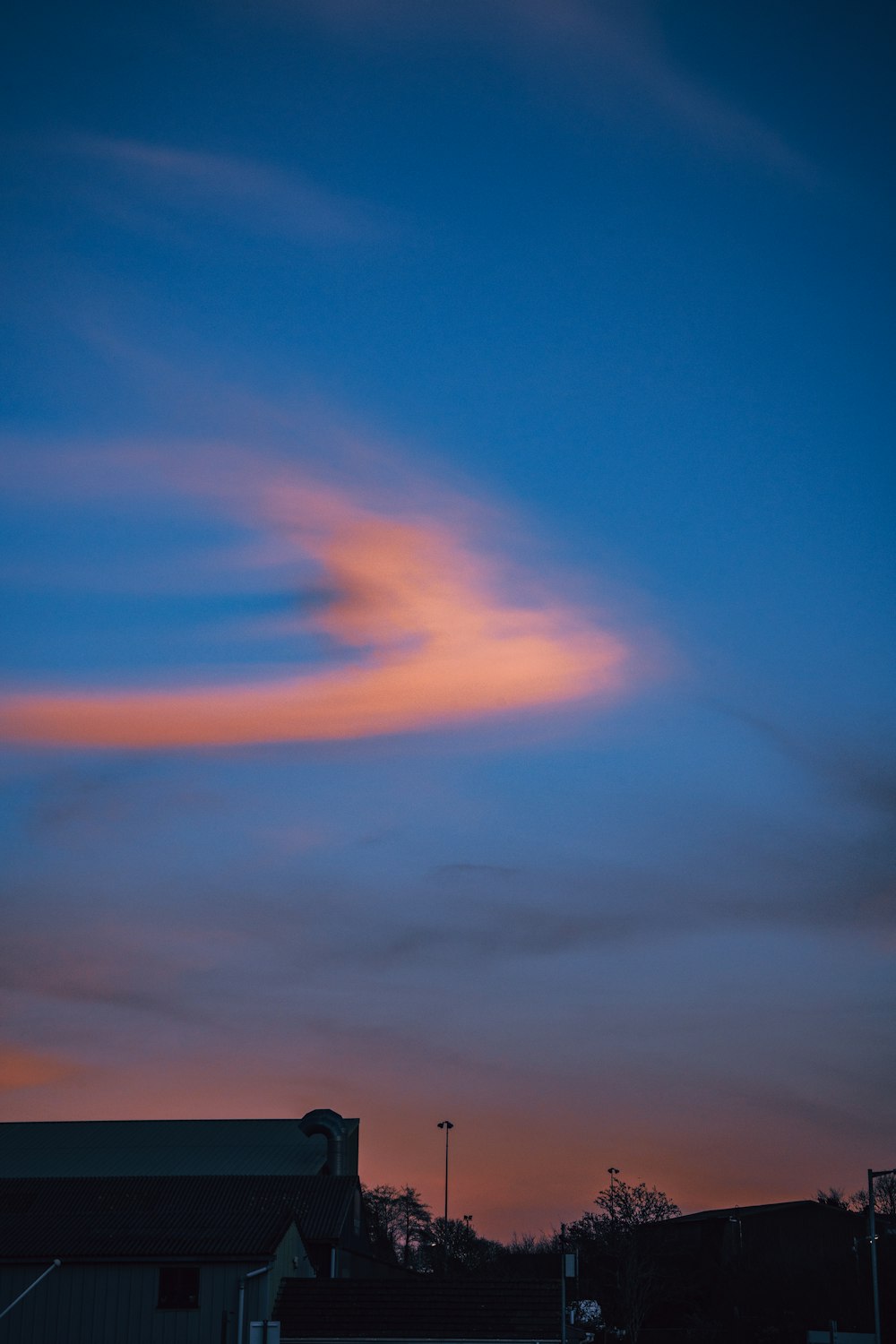 a pink cloud is in the sky above a building