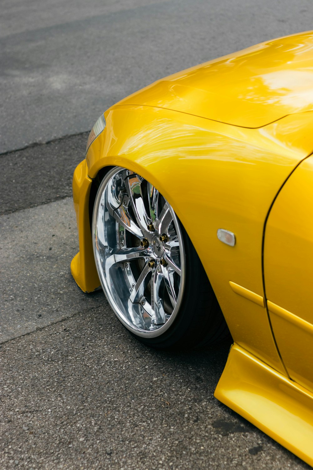 a yellow sports car parked on the side of the road