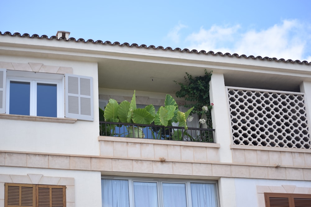 a building with a balcony with plants on the balconies