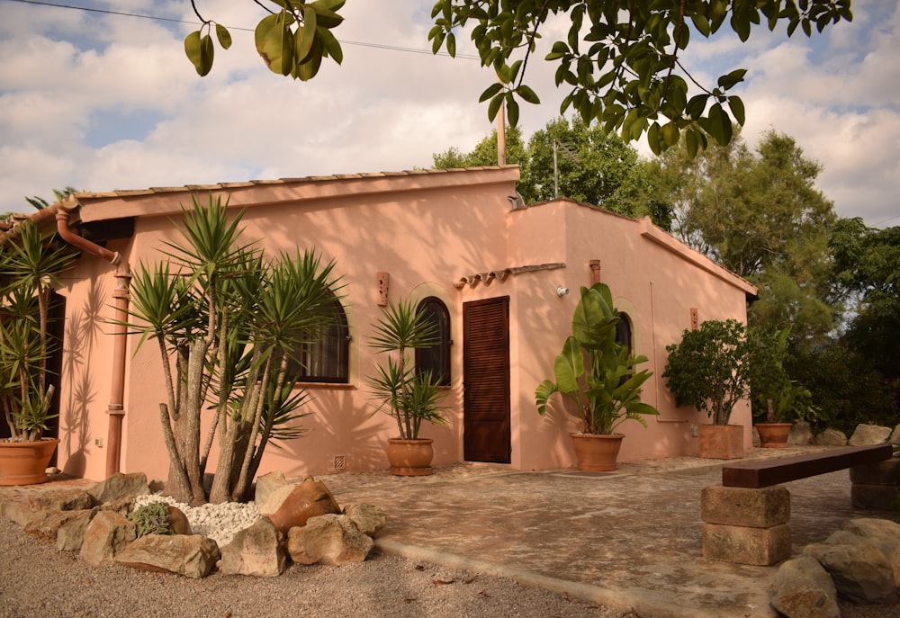 a pink house with potted plants in front of it