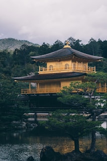 a yellow building sitting on top of a lush green hillside