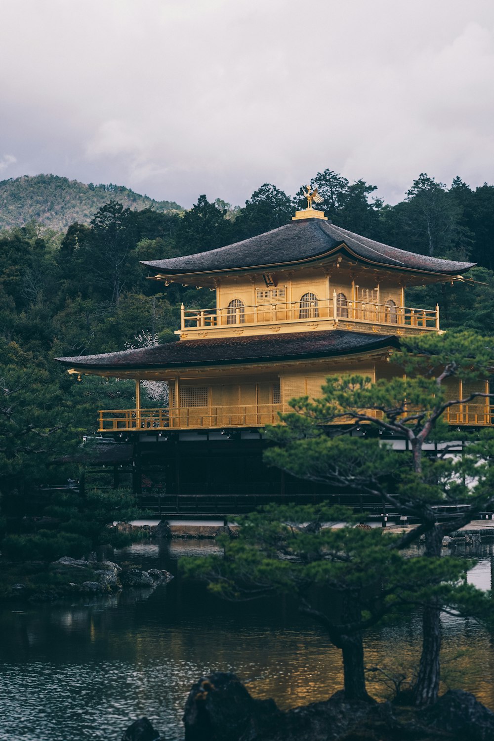 a yellow building sitting on top of a lush green hillside