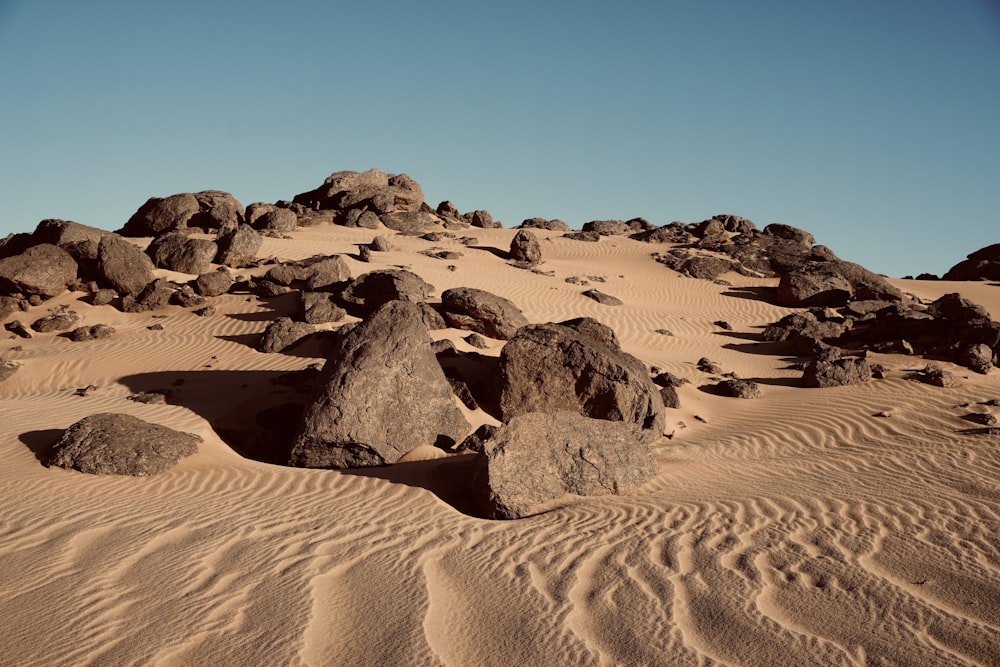 rocks and sand in the desert under a blue sky