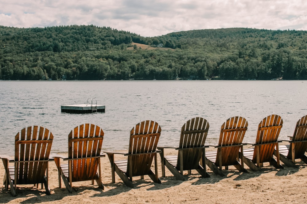 a row of chairs sitting on top of a sandy beach