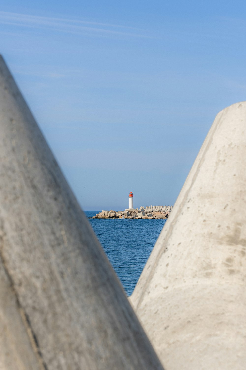 Blick auf einen Leuchtturm hinter einer Betonmauer