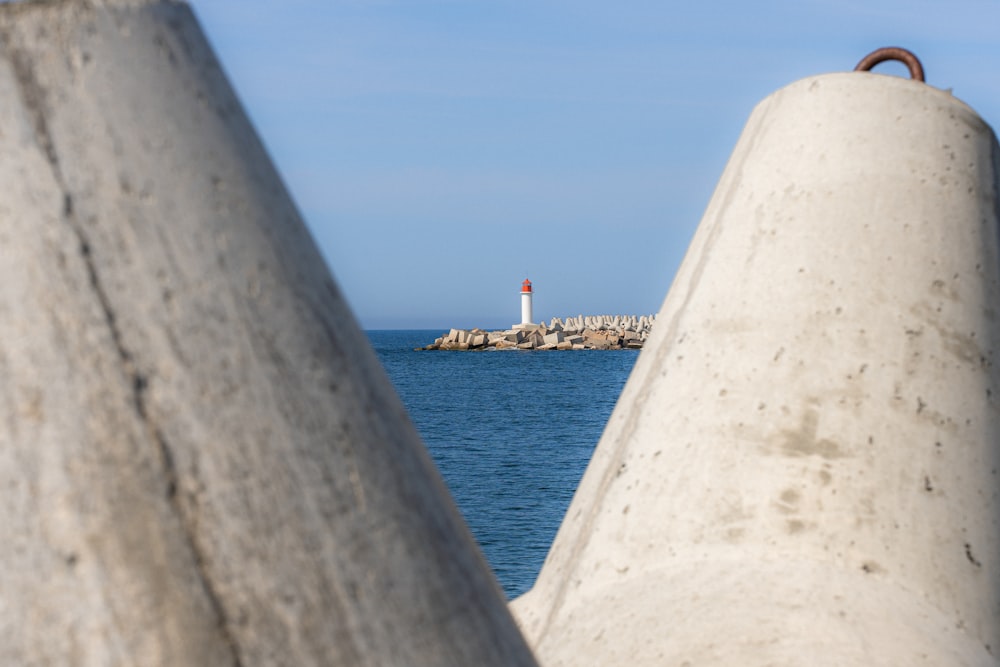 a view of a lighthouse from behind a concrete wall
