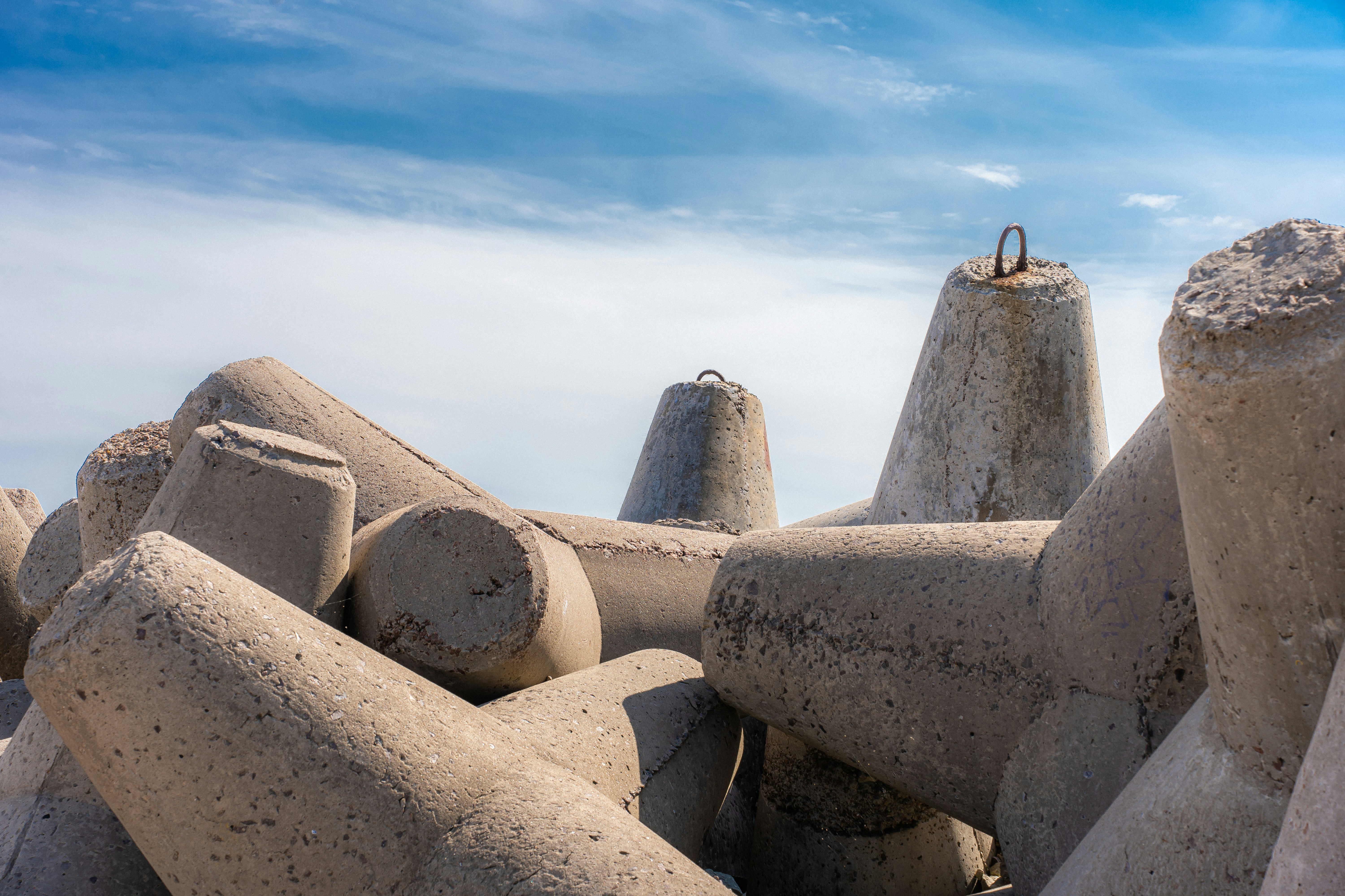 a group of cement sculptures sitting on top of a beach