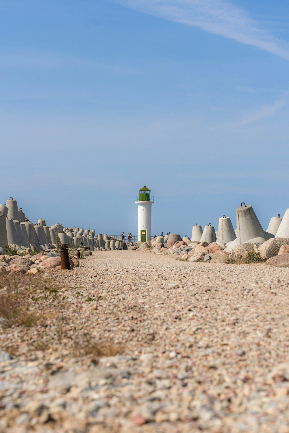 a lighthouse on a rocky beach with a sky background