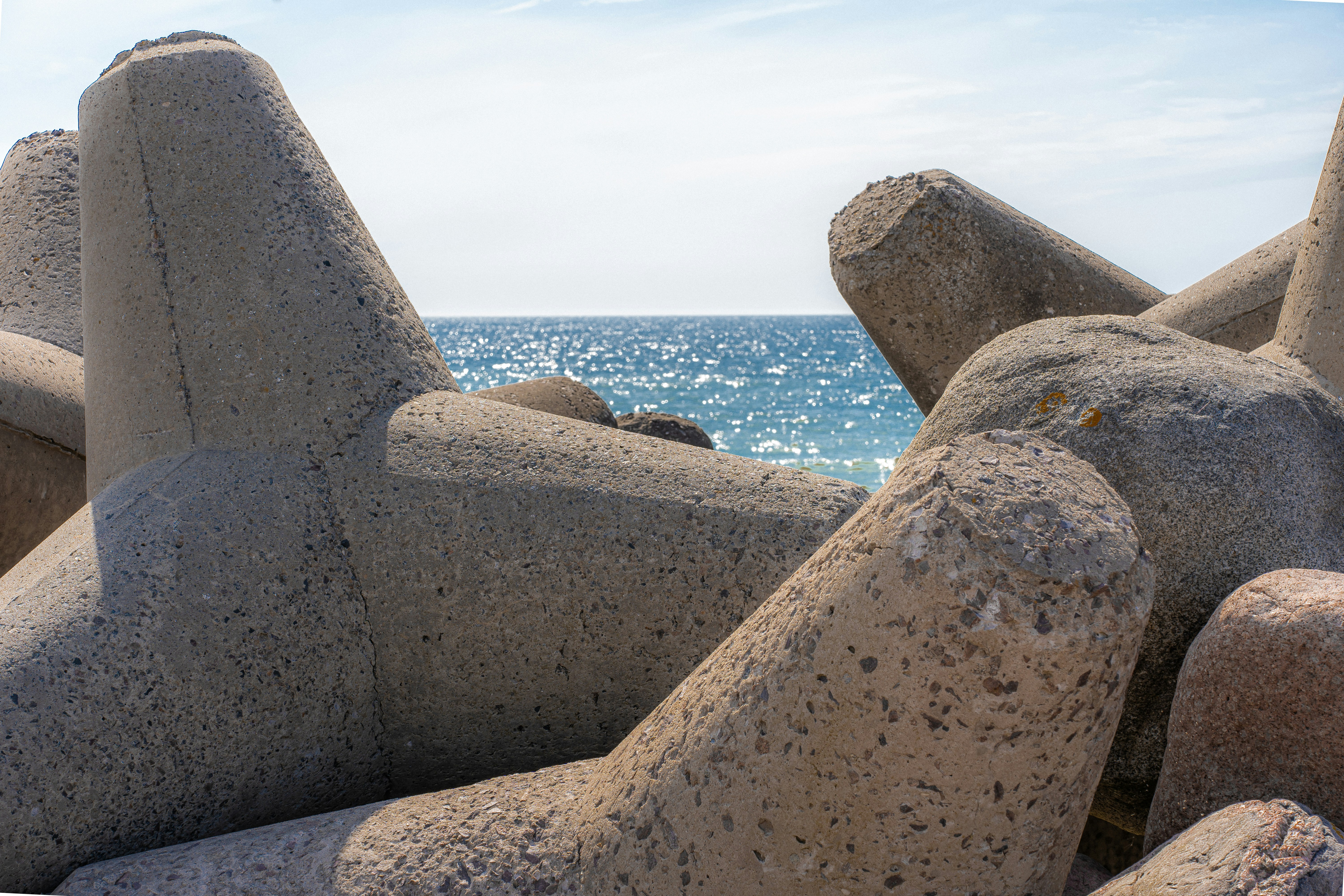 a rock formation on the beach with the ocean in the background
