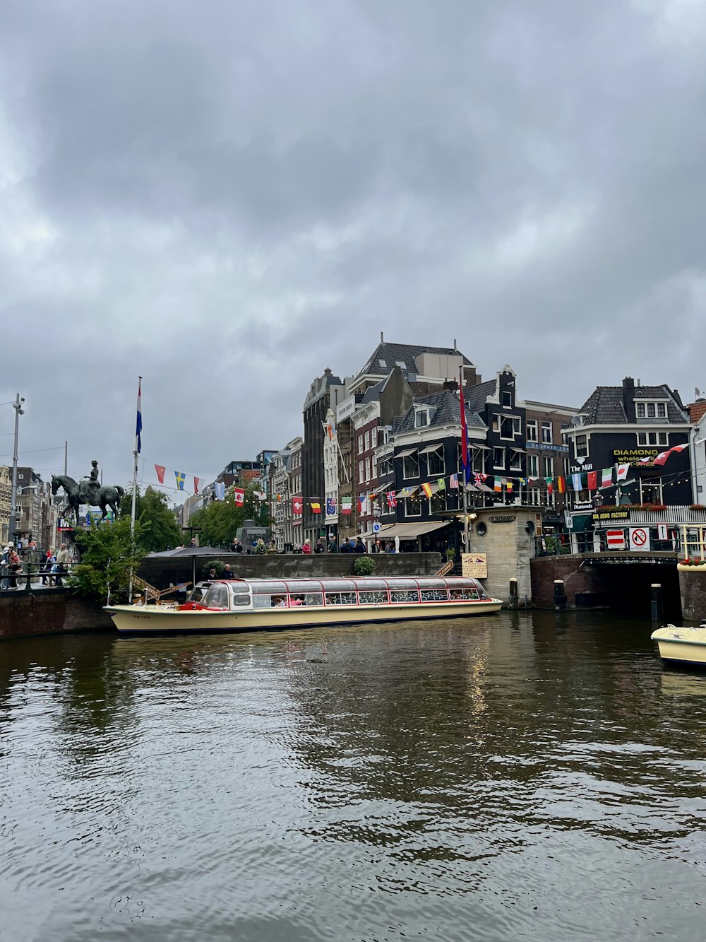 a river with several boats on it and buildings in the background