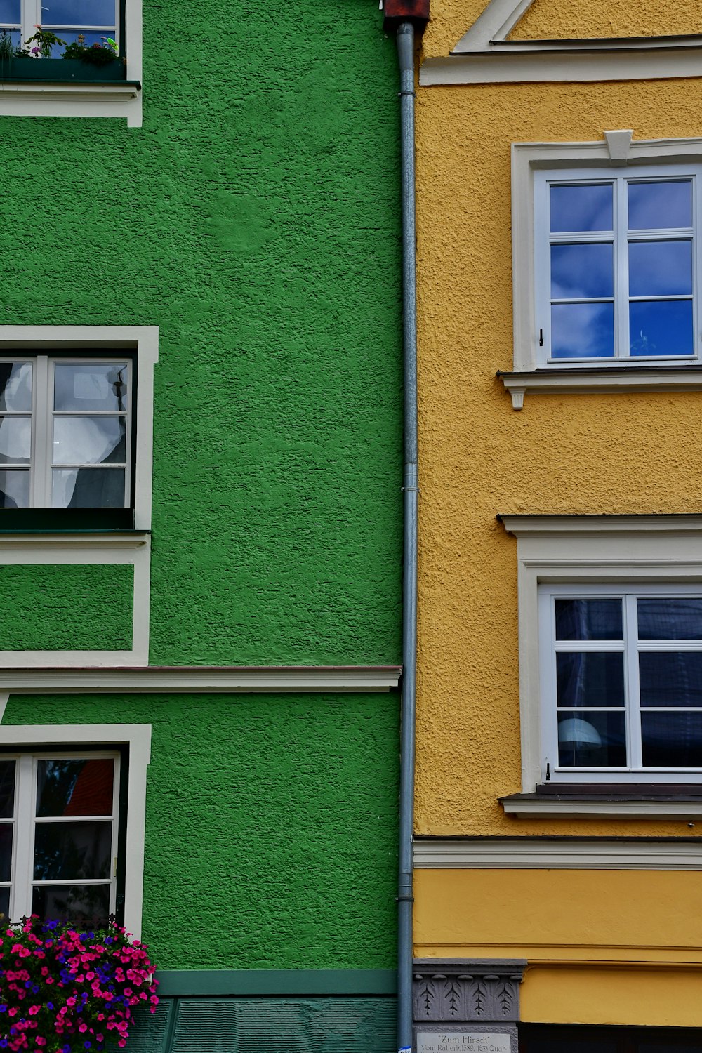 a green and yellow building next to a yellow and green building