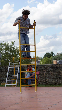 A smiling physiotherapist assisting a patient with posture correction on a ladder barrel.
