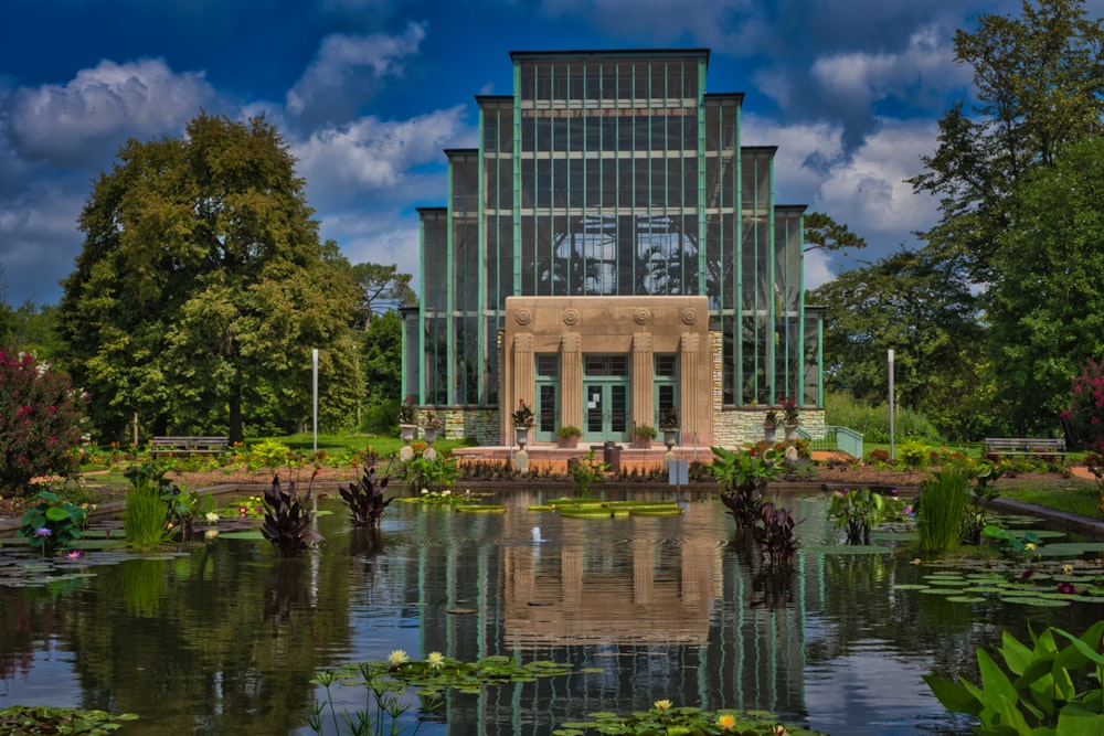 a large building with a pond in front of it