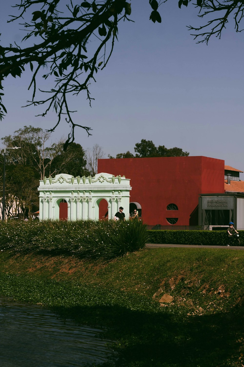 a red and white building sitting next to a body of water