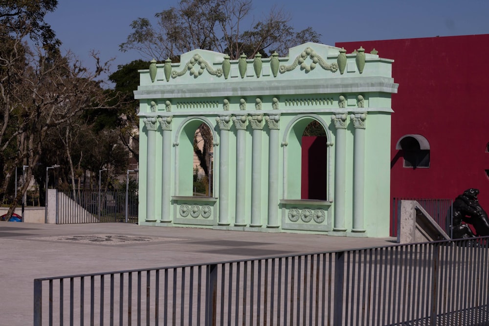 a green building with a red building behind it