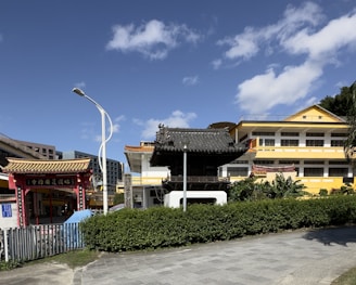 a yellow building with a black roof next to a street
