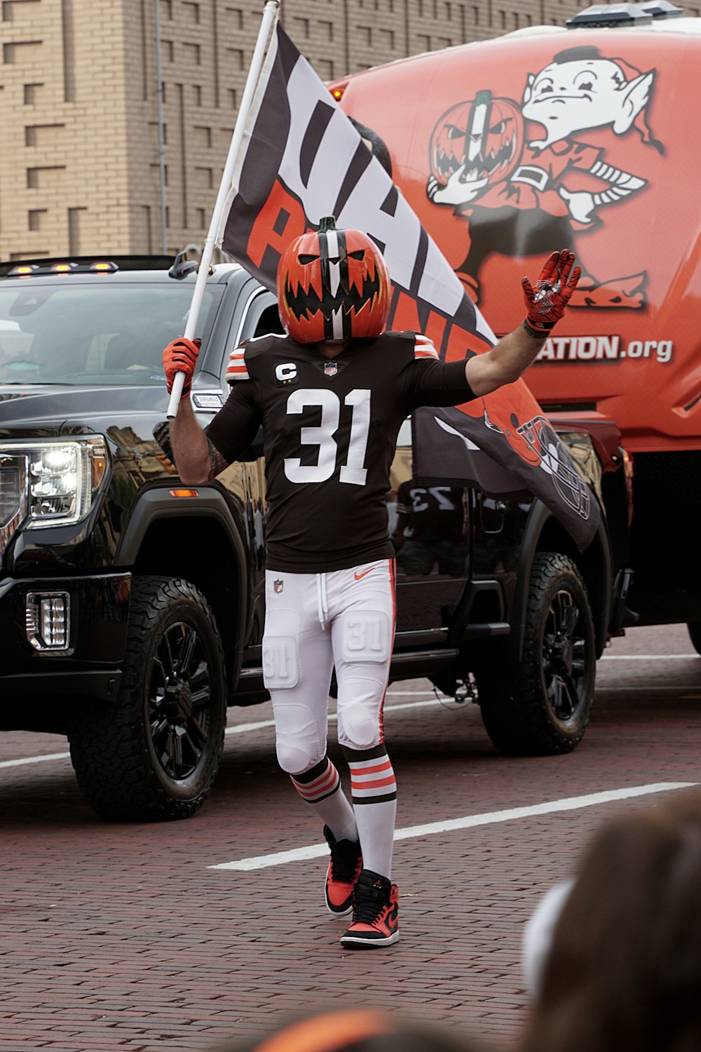 a football player walking down a street holding a flag