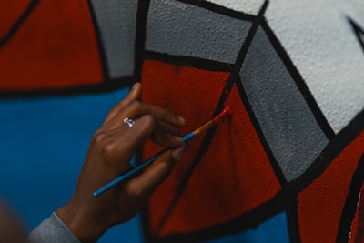 A close-up of hands painting a mural with powerful messages.