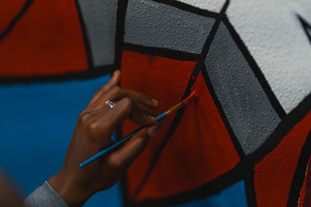 A close-up of hands working on a colorful art project.