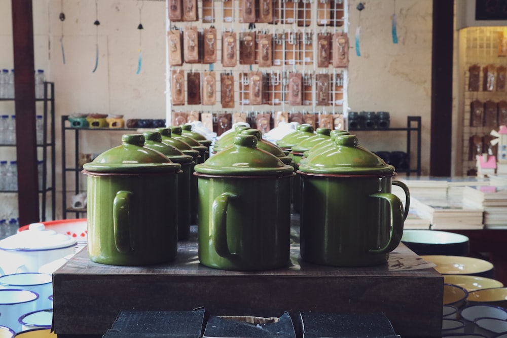 a group of green coffee mugs sitting on top of a table