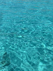A close-up of turquoise water rippling under a clear blue sky.