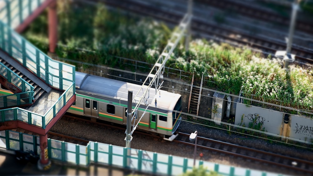 a train traveling down train tracks next to a green roof