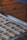 Baking tray lined with parchment paper holds several bone-shaped cookies inside an oven. The cookies appear golden-brown and lightly dusted with flour.