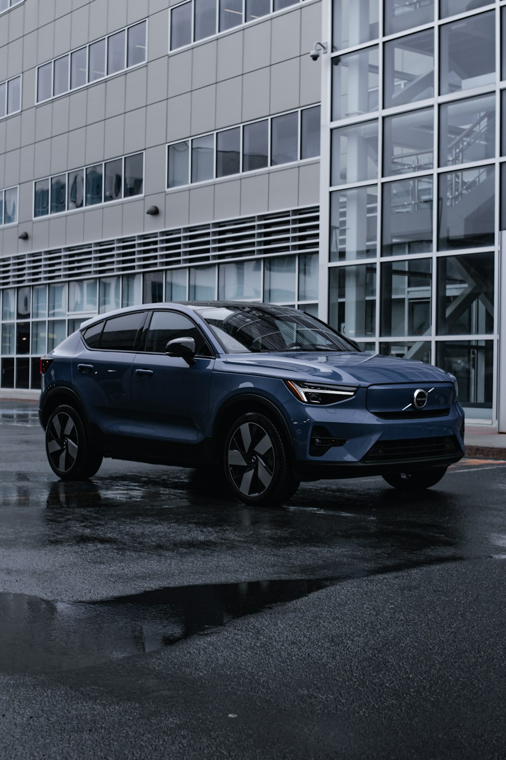 a blue volvo suv parked in front of a building