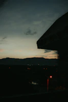 A moody video frame featuring a cityscape at dusk with glowing lights.